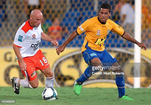 Danny Tiatto of Roar looks to get around Tahj Minniecon of United during the round 21 A-League match between Gold Coast United and Brisbane Roar at...