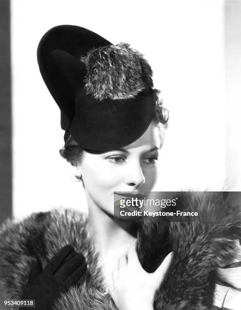 Joan Fontaine avec un chapeau en velours noir et pompon en renard à Hollywood, Californie,Etats-Unis, le 11 octobre 1938.