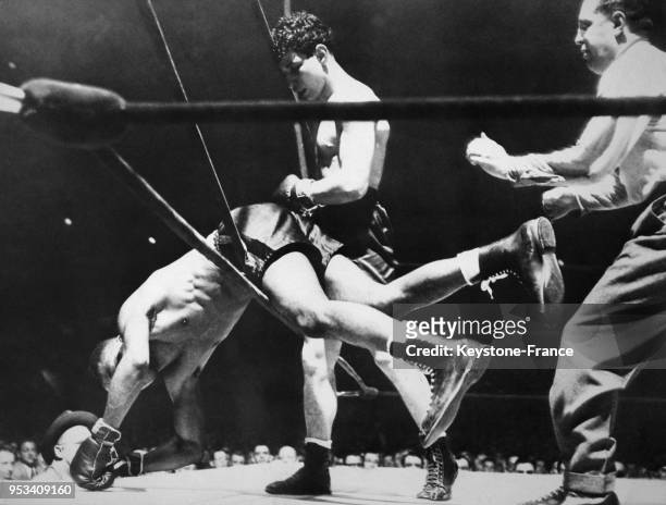 Le boxeur américain Bob Montgomery perd son titre de champion des poids légers enb perdant l'équilibre par-dessus le ring contre Tony Pellone au...