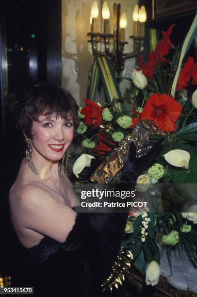 Portrait de l'actrice Sabine Azéma portant un bouquet de fleurs le 4 mars 1985, Paris, France.