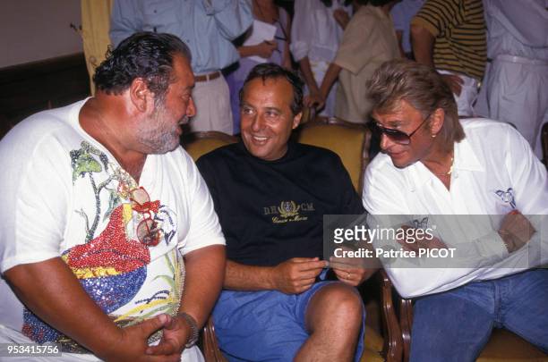 Carlos, Daniel Hechter et Johnny Hallyday au mariage de Eddie Barclay avec Caroline Giganti à Saint-Tropez, France, en juillet 1991.