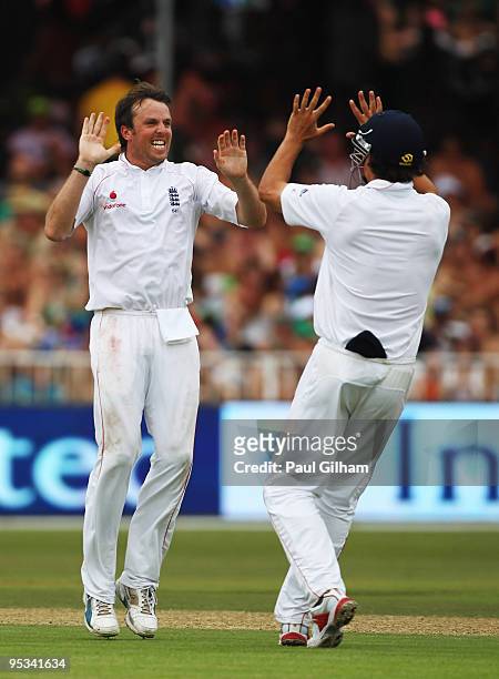 Graeme Swann of England celebrates with Alastair Cook after taking the wicket of Jacques Kallis of South Frica for 75 runs during day one of the...