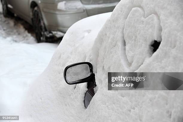 Driving mirror on a car covered by snow is seen in a street during a heavy snowfall in Kiev on December 22, 2009. AFP PHOTO/ SERGEI SUPINSKY