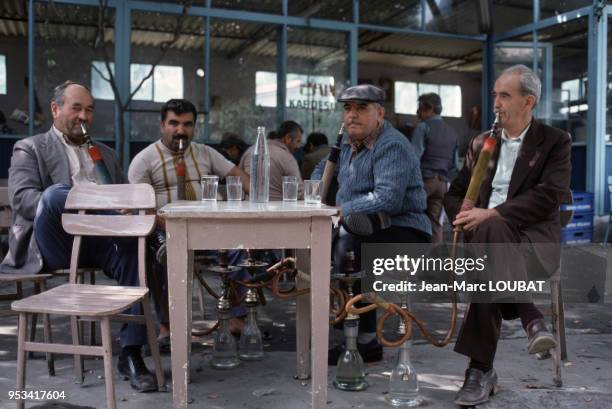 Turcs fumant le narguilé ou chicha à la terrase d'un bar à Istanbul dans les années 80, Turquie. Circa 1980.