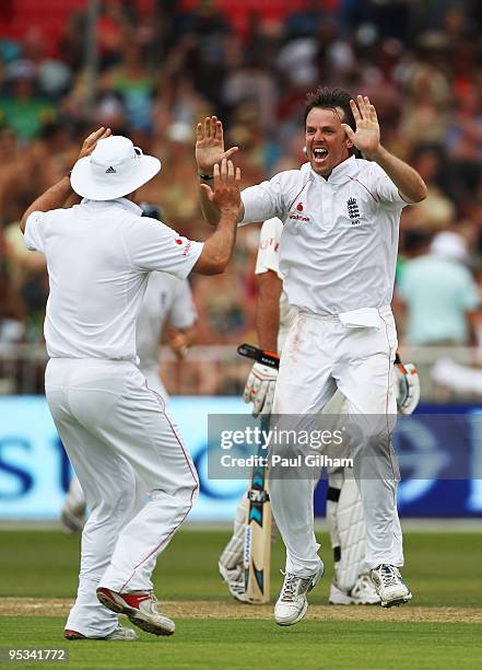 Graeme Swann of England celebrates with captain Andrew Strauss after taking the wicket of Jacques Kallis of South Frica for 75 runs during day one of...