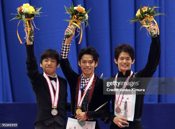 2nd place winner Nobunari Oda, winner Daisuke Takahashi and 3rd place winner Takahiko Kozuka pose on the podium after competing in the Men Free...