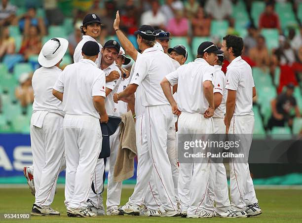 Alastair Cook of England celebrates with James Anderson and his team-mates after running out Graeme Smith of South Africa for 75 runs during day one...