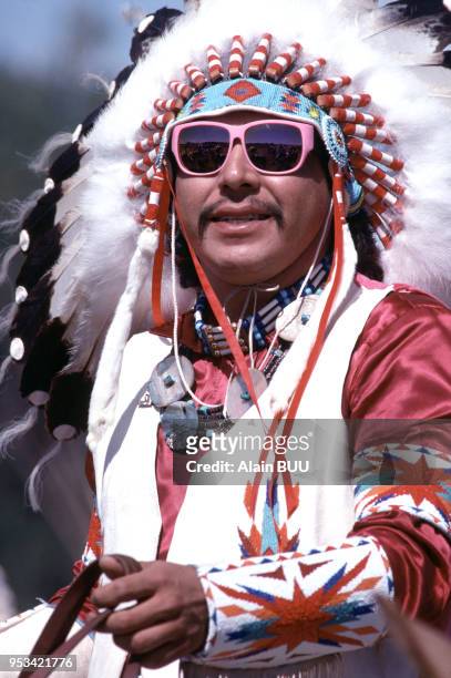 Portrait d'un Indien d'Amérique avec coiffe traditionnelle et lunettes de soleil circa 1980 aux États-Unis.