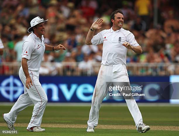 Graeme Swann of England celebrates with captain Andrew Strauss after taking the wicket of Jacques Kallis of South Frica for 75 runs during day one of...