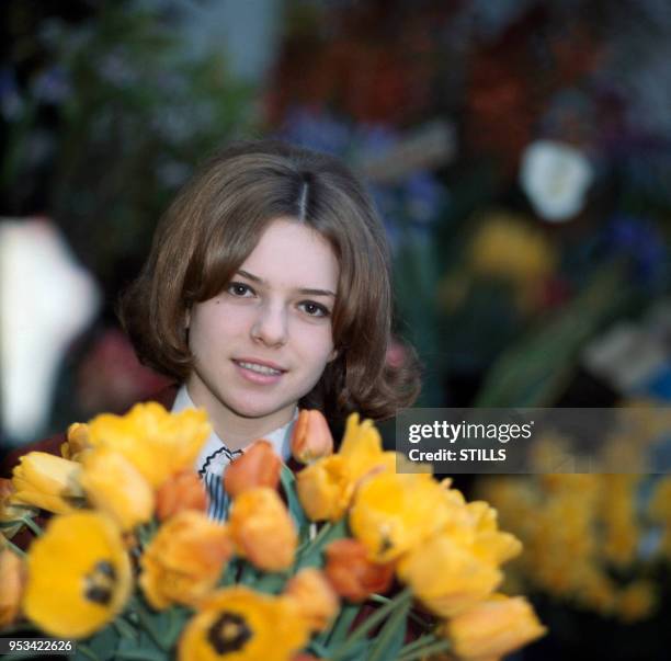 Portrait de la chanteuse France Gall adolescente avec un bouquet de fleurs, circa 1960.