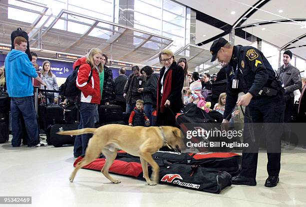 Cpl. Frederick of the Wayne County Airport Police and his bomb-sniffing dog Spencer patrol at the Detroit Metropolitan Airport December 26, 2009 in...