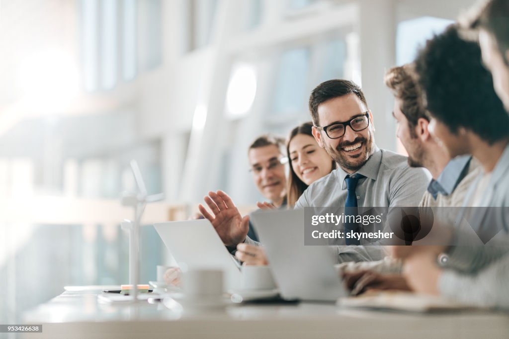 Happy businessman talking to his colleagues on a meeting in the office,