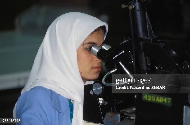 Femme ouvrière regardant dans un microscope dans un usine d'électronique en mai 1992 à Sidi Bel Abbès en Algérie.