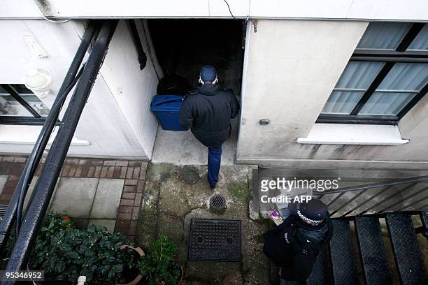 Police officers enter on December 26, 2009 the entrance building in central London where a student who is alleged to have attempted to blow up a...