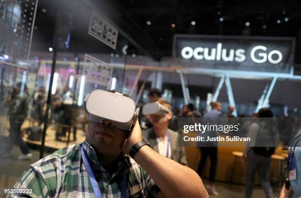 Attendees use the Oculus Go VR headset during the F8 Facebook Developers conference on May 1, 2018 in San Jose, California. Facebook CEO Mark...