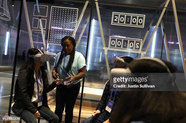 Attendees use the Oculus Go VR headset during the F8 Facebook Developers conference on May 1, 2018 in San Jose, California. Facebook CEO Mark...
