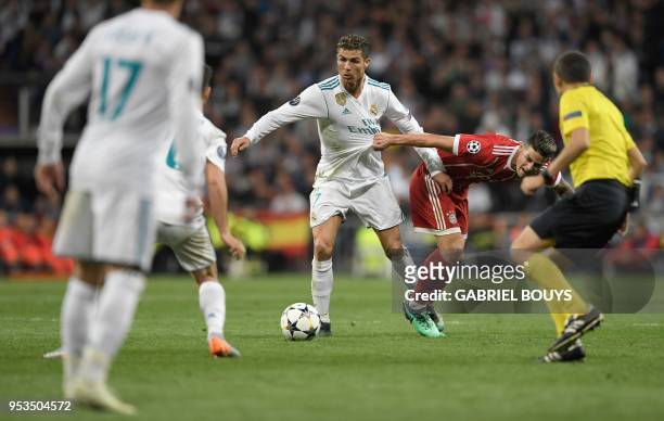 Real Madrid's Portuguese forward Cristiano Ronaldo and Bayern Munich's Colombian midfielder James Rodriguez vie for the ball during the UEFA...