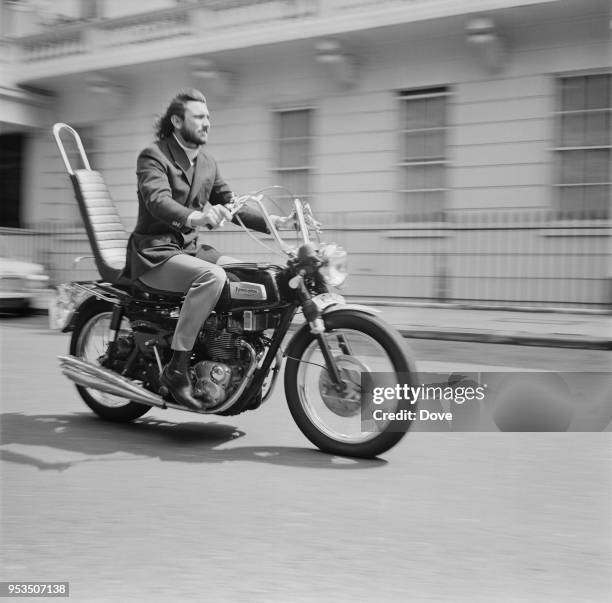 Australian actor and former model George Lazenby on his motorcycle, UK, 27th July 1970.