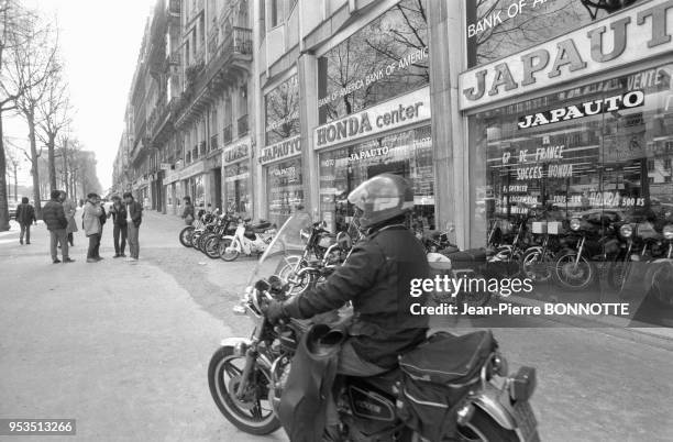 Motocycliste devant l'Espace Honda Japauto spécialisé dans les motos, scooters et accessoires pour deux roues japonais en mars 1983 à Paris, France.