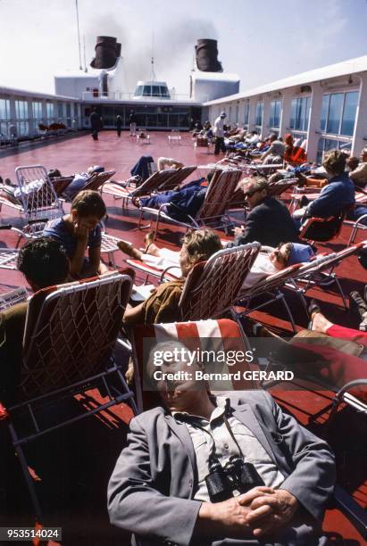 Croisièristes se reposant sur le pont d'un bateau en novembre 1982, Finlande.