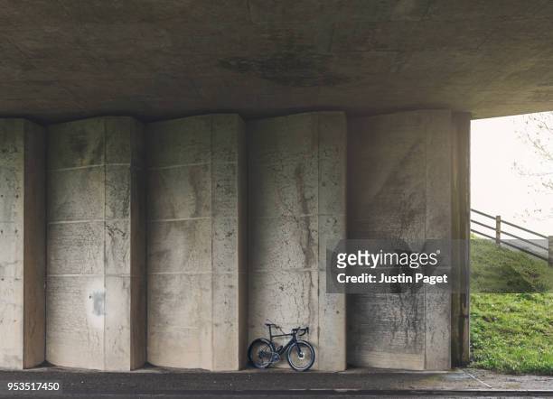bike against concrete underpass wall - strassenunterführung stock-fotos und bilder