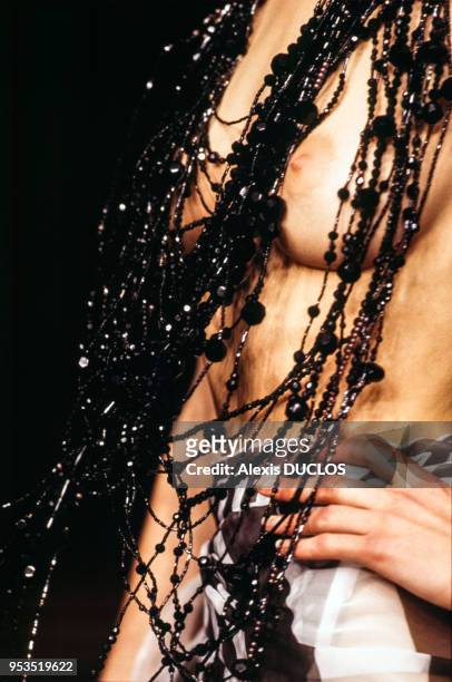 Top model vêtue seulement d'un collier laissant apparaître la poitrine dans le défilé Popy Moreni en octobre 1996 à Paris, France.