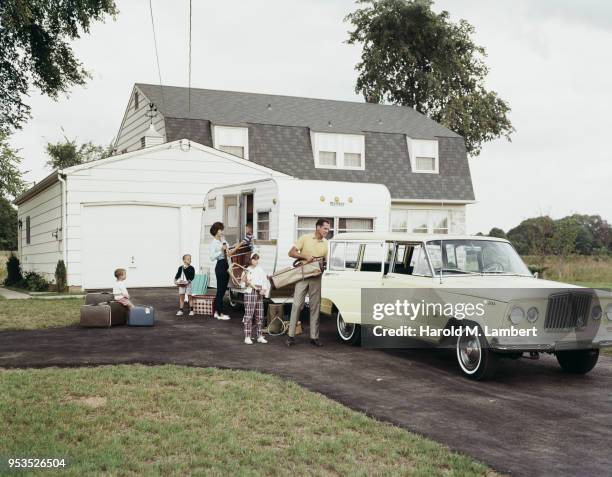 FAMILY LOADING LUGGAGE IN HATCHBACK OF CAR