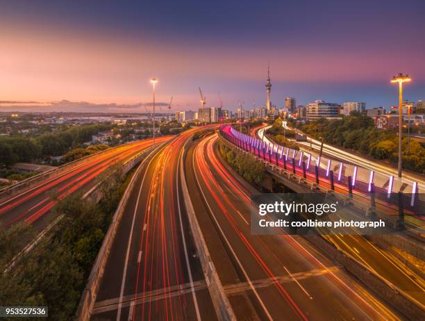 evening scene of auckland city with road foreground - new zealand city stock pictures, royalty-free photos & images