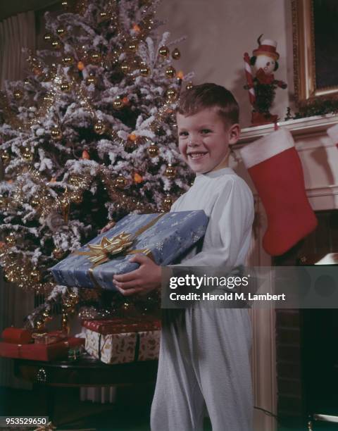 PORTRAIT OF BOY HOLDING CHRISTMAS GIFT, SMILING