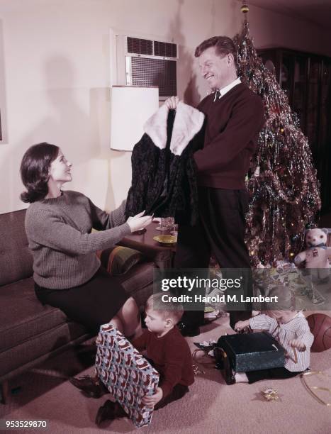 FAMILY WITH CHRISTMAS GIFTS IN LIVING ROOM