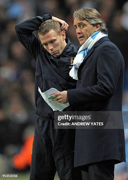 Manchester City's Italian manager Roberto Mancini talks to Manchester City's Welsh forward Craig Bellamy during the English Premier League football...