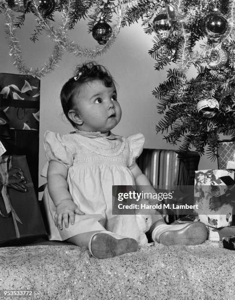 BABY GIRL LOOKING AT CHRISTMAS TREE