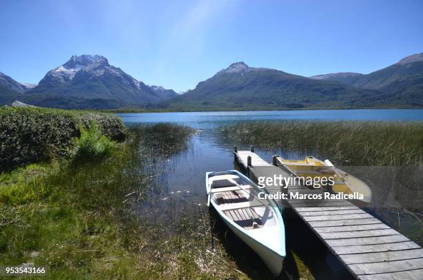 boats by the lake at patagonian lake - radicella stock pictures, royalty-free photos & images