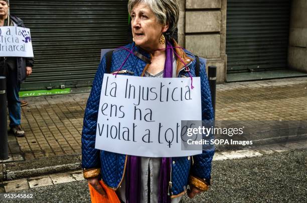 Woman is seen carrying a sign hanging from her neck with the text "injustice has violated us all". 50,000 people have demonstrated in the streets of...