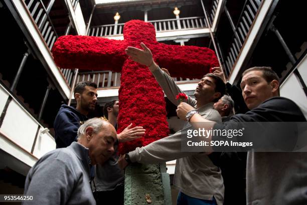 Men in the "Corrala de Santiago" try to put up the cross that will be part of an altar during the upcoming "Dia de la cruz" in Granada . El día de la...