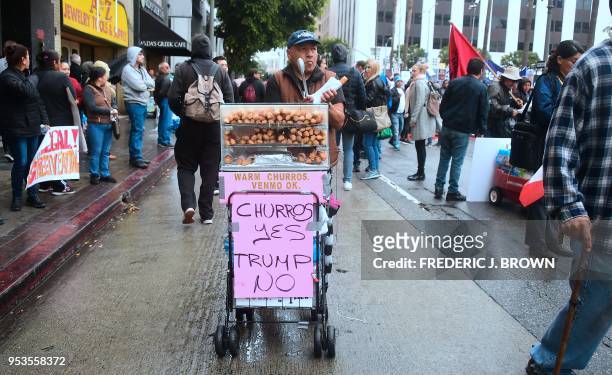Snack vendor sells churros demonstrators march through the city during May Day protests in Los Angeles, California on May 1, 2018.