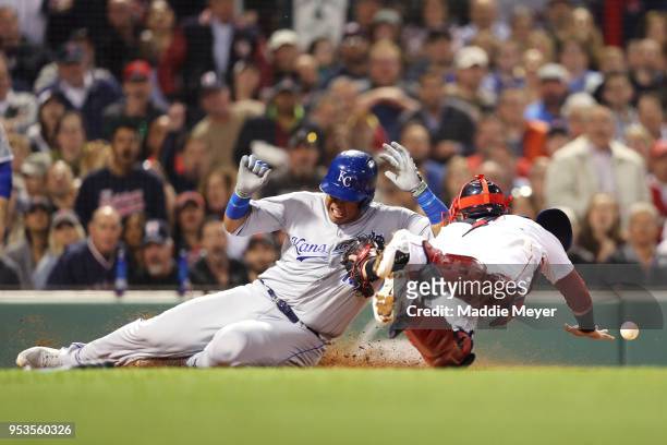 Salvador Perez of the Kansas City Royals slides into home plate scoring a run past Christian Vazquez of the Boston Red Sox during the fourth inning...