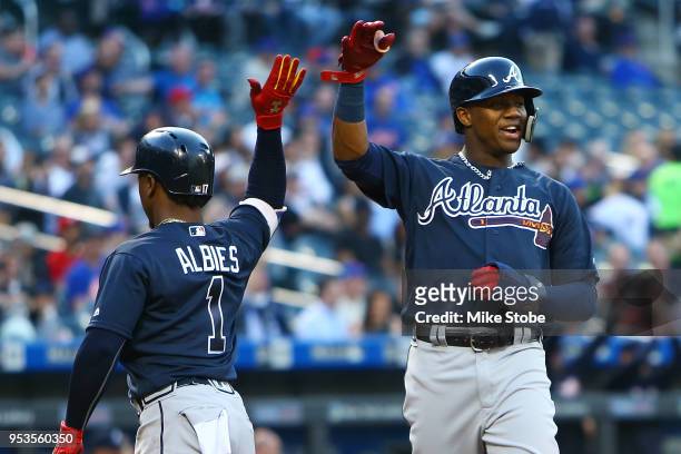 Ozzie Albies and Ronald Acuna Jr. #13 of the Atlanta Braves celebrate after scoring on an RBI double by Freddie Freeman in the first inning against...
