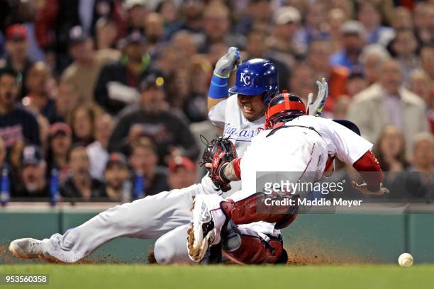 Salvador Perez of the Kansas City Royals slides into home plate scoring a run past Christian Vazquez of the Boston Red Sox during the fourth inning...