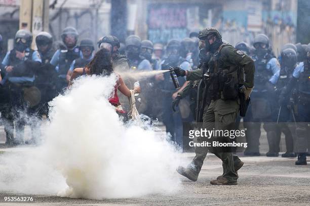 Riot police officer pepper-sprays a demonstrator during a protest against austerity measures in Hato Rey neighborhood of San Juan, Puerto Rico, on...