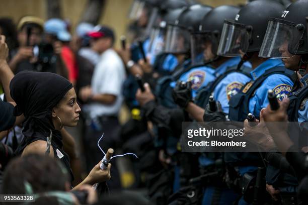 Demonstrator confronts riot police officers during a protest against austerity measures in the Hato Rey neighborhood of San Juan, Puerto Rico, on...