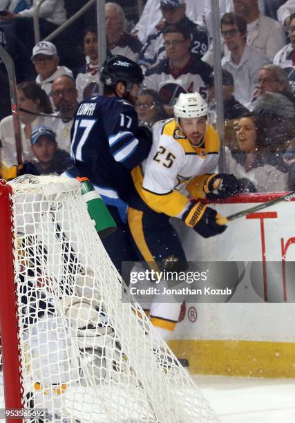 Adam Lowry of the Winnipeg Jets checks Alexei Emelin of the Nashville Predators along the end boards during first period action in Game Three of the...