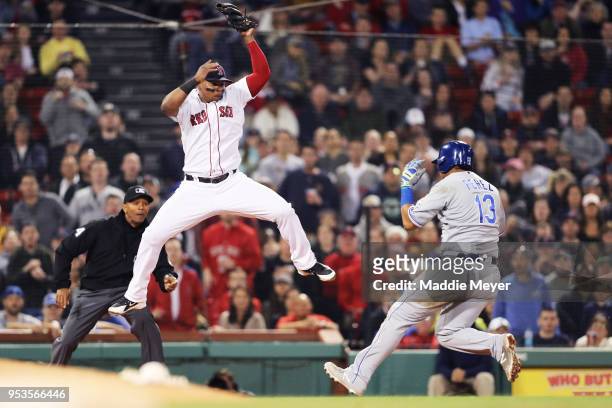 Salvador Perez of the Kansas City Royals beats the tag from Rafael Devers of the Boston Red Sox during the eighth inning at Fenway Park on May 1,...