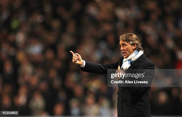 Roberto Mancini the manager of Manchester City gives instructions to his players during the Barclays Premier League match between Manchester City and...