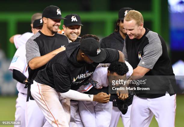 Yadiel Rivera of the Miami Marlins is mobbed by teammates after hitting a walk-off single in the 10th inning against the Philadelphia Phillies at...