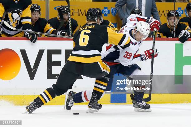 Alex Chiasson of the Washington Capitals attempts to skate the puck past Jamie Oleksiak of the Pittsburgh Penguins during the third period in Game...