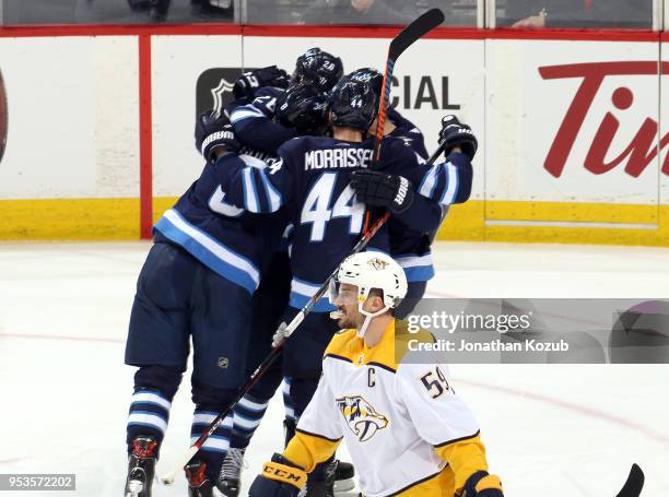 Roman Josi of the Nashville Predators skates away as Jacob Trouba, Blake Wheeler, Josh Morrissey and Paul Stastny of the Winnipeg Jets celebrates a...