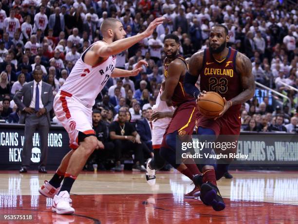 LeBron James of the Cleveland Cavaliers dribbles the ball as Jonas Valanciunas of the Toronto Raptors defends in the second half of Game One of the...