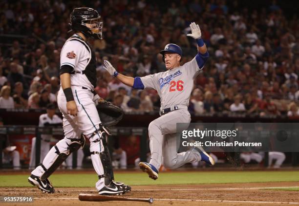 Chase Utley of the Los Angeles Dodgers slides into home-plate to score a run past catcher Alex Avila of the Arizona Diamondbacks during the fourth...