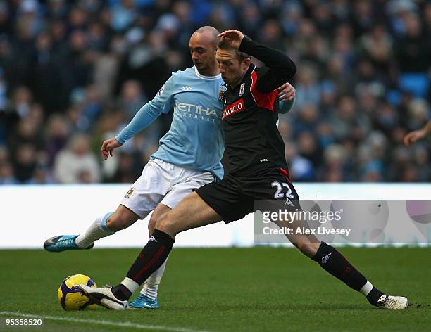 Stephen Ireland of Manchester City is tackled by Danny Collins of Stoke City during the Barclays Premier League match between Manchester City and...